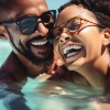 a man and woman laugh together in a pool