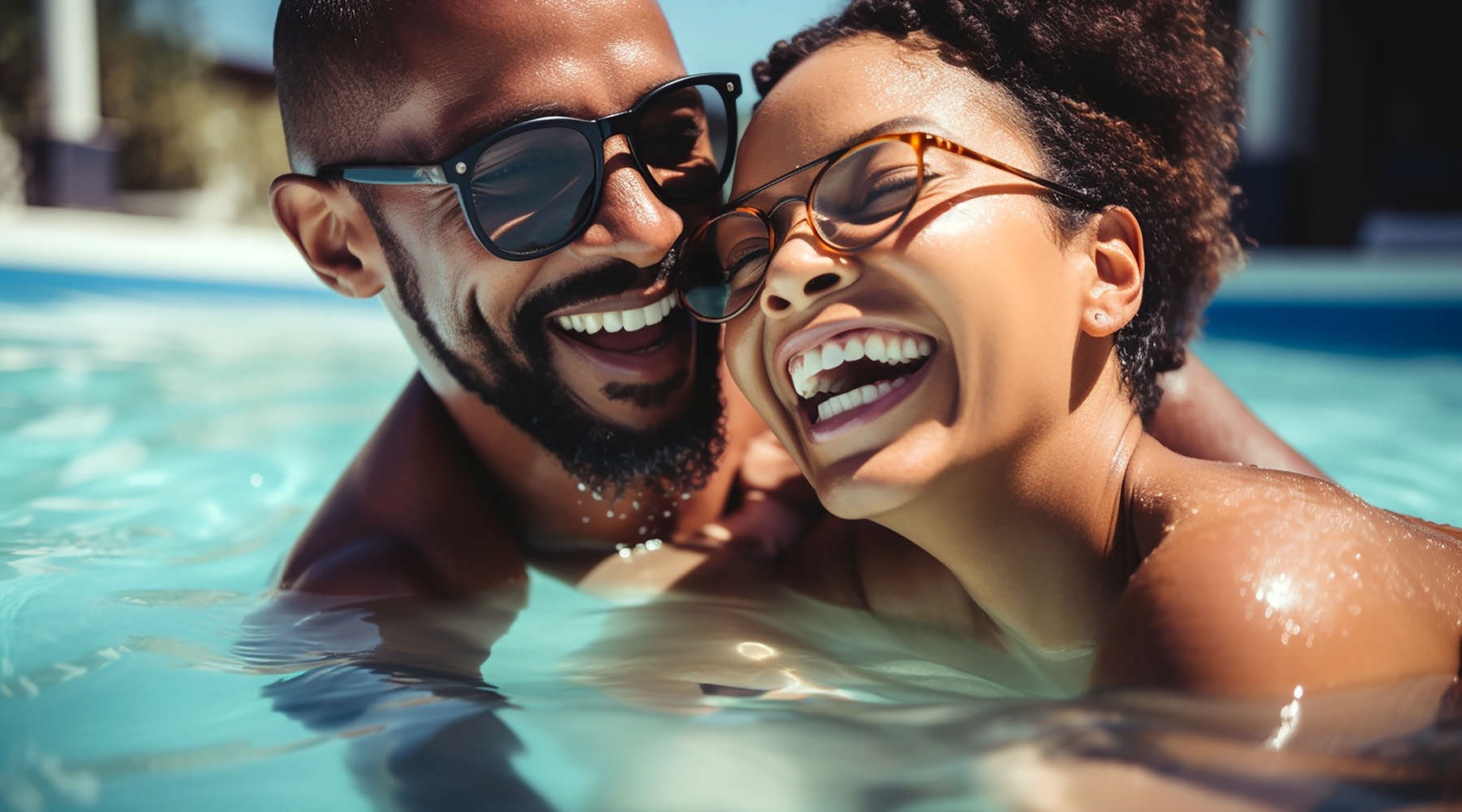 a man and woman laugh together in a pool